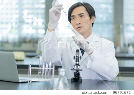 Researcher looking at test tubes in laboratory 96791671