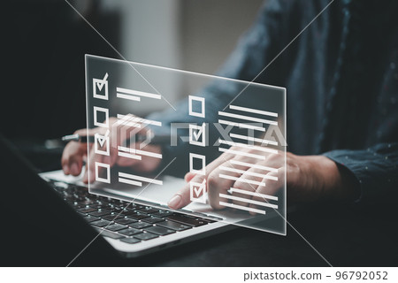 man using laptop questionnaire with checkbox, survey form online, answer questions in the exam of test business checklist and filling survey form online. 96792052