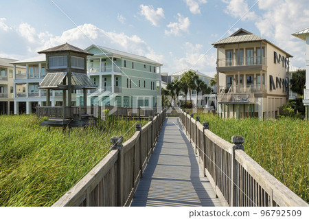 Destin, Florida- Boardwalk over the tall grass plants near the lake and residences 96792509