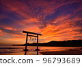 A torii standing on the sea dyed in the bright red sunset 96793689