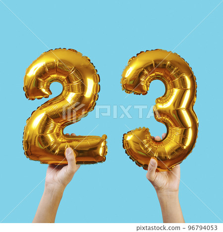 holds two balloons forming the number 23 holds two balloons forming the number 23 96794053