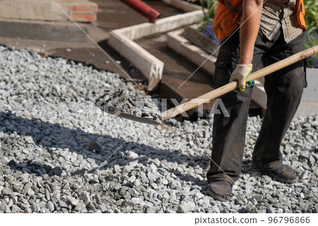 Male construction worker is loading gravel Male construction worker is loading gravel 96796866