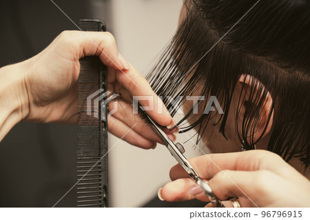 Hair care, beauty industry concept. Hairdresser doing haircut closeup of work. Hairstylist does Hair care, beauty industry concept. Hairdresser doing haircut closeup of work. Hairstylist does 96796915