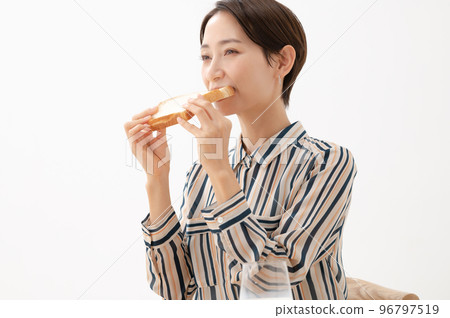 A woman eating bread 96797519