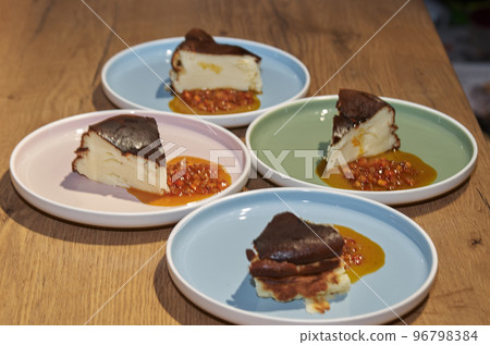 Piece of cheesecake with sea buckthorn jam on a plate 96798384