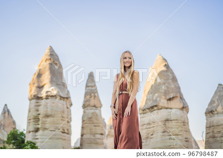 Woman tourist on background of Unique geological formations in Love Valley in Cappadocia, popular travel destination in Turkey Woman tourist on background of Unique geological formations in Love Valley in Cappadocia, popular travel destination in Turkey 96798487