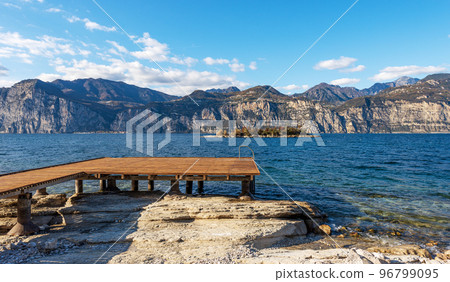 Beach and Wooden Pier of Lake Garda - Malcesine Village Veneto Italy Beach and Wooden Pier of Lake Garda - Malcesine Village Veneto Italy 96799095