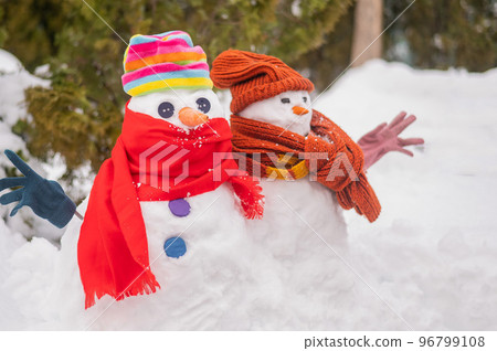 A couple of snowmen in hats and scarves. Winter fun. 96799108