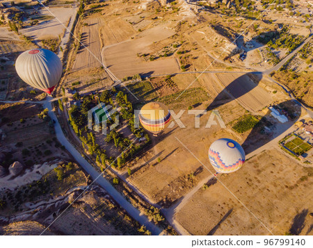 Colorful hot air balloons flying over at fairy chimneys valley in Nevsehir, Goreme, Cappadocia Turkey. Spectacular panoramic drone view of the underground city and ballooning tourism. High quality Colorful hot air balloons flying over at fairy chimneys valley in Nevsehir, Goreme, Cappadocia Turkey. Spectacular panoramic drone view of the underground city and ballooning tourism. High quality 96799140