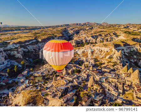 Colorful hot air balloons flying over at fairy chimneys valley in Nevsehir, Goreme, Cappadocia Turkey. Spectacular panoramic drone view of the underground city and ballooning tourism. High quality Colorful hot air balloons flying over at fairy chimneys valley in Nevsehir, Goreme, Cappadocia Turkey. Spectacular panoramic drone view of the underground city and ballooning tourism. High quality 96799141