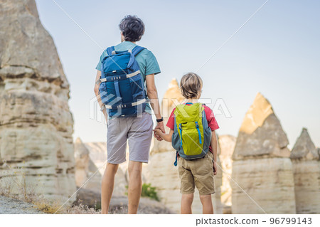 Father and son tourists on background of Unique geological formations in Love Valley in Cappadocia, popular travel destination in Turkey. Traveling with children in Turkey concept Father and son tourists on background of Unique geological formations in Love Valley in Cappadocia, popular travel destination in Turkey. Traveling with children in Turkey concept 96799143