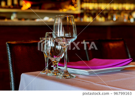 Beautiful table setting with crockery and flowers for a party, wedding reception or other festive event. Glassware and cutlery for catered event dinner. Beautiful table setting with crockery and flowers for a party, wedding reception or other festive event. Glassware and cutlery for catered event dinner. 96799163