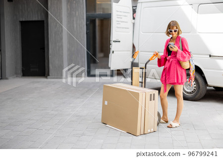 Woman checks packages delivered home 96799241