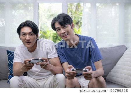 Asian gay LGBT men couple play video games at home Asian gay LGBT men couple play video games at home 96799258