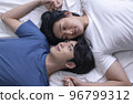 Asian gay couple relaxing and lying down in bed 96799312