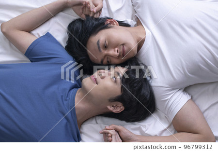 Asian gay couple relaxing and lying down in bed Asian gay couple relaxing and lying down in bed 96799312