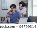Asian gay couple holding credit card and using laptop computer 96799314