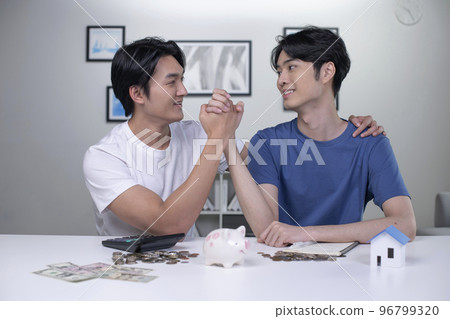 Asian gay couple saving money to buy a house Asian gay couple saving money to buy a house 96799320