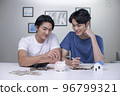 Asian gay couple saving money to buy a house. 96799321