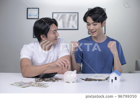 Asian gay couple saving money to buy a house Asian gay couple saving money to buy a house 96799350