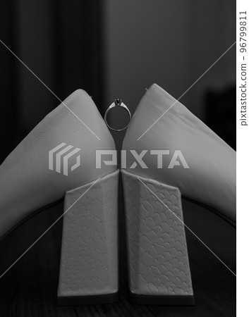 Ring with a stone on white women's leather shoes. Bride's accessories, bride's morning Ring with a stone on white women's leather shoes. Bride's accessories, bride's morning 96799811