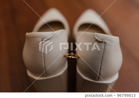 Ring with a stone on white women's leather shoes. Bride's accessories, bride's morning Ring with a stone on white women's leather shoes. Bride's accessories, bride's morning 96799813