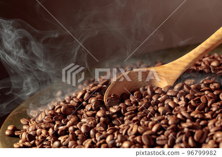 Coffee beans are smoky in a roasting pan. 96799982