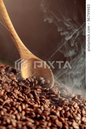 Coffee beans are smoky in a roasting pan. 96799983