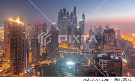 View of various skyscrapers in tallest recidential block in Dubai Marina aerial night to day timelapse View of various skyscrapers in tallest recidential block in Dubai Marina aerial night to day timelapse 96800081