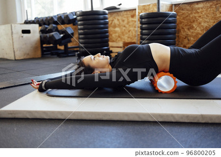 Close up of massage roller for body massage. Sports gear for yoga and Pilates Close up of massage roller for body massage. Sports gear for yoga and Pilates 96800205