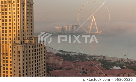 Bluewaters island with modern architecture and ferris wheel covered by morning fog aerial timelapse. 96800526