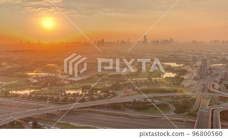 Sunrise over Golf course with green lawn and lakes, villa houses behind it timelapse. 96800560