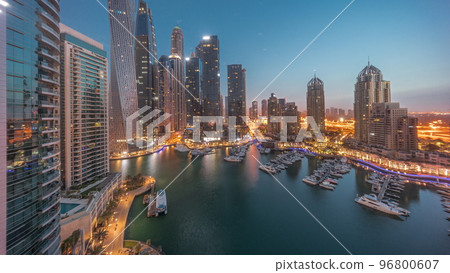 Dubai marina tallest skyscrapers and yachts in harbor aerial night to day timelapse. 96800607