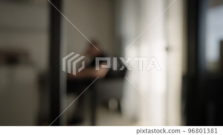 Blurred background of one man sitting in diningroom with natural window light Blurred background of one man sitting in diningroom with natural window light 96801381