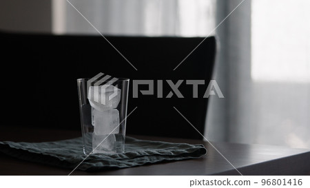 man making iced coffee with milk in thumbler glass on walnut table 96801416