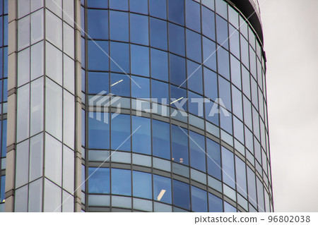 Modern glass building against a grey sky 96802038