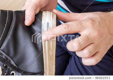 Old torn shoe in hands of man 96802051