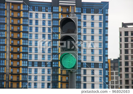 Green traffic light on the background of buildings Green traffic light on the background of buildings 96802083