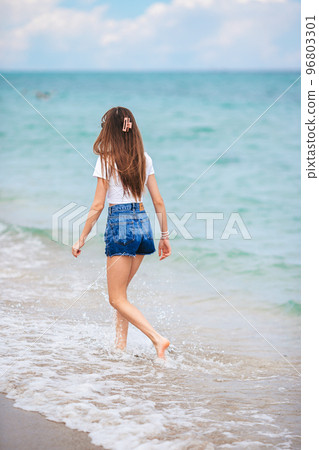 Back. view of happy girl running on the beach 96803301