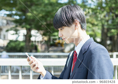 男高中生在上學時看智能手機 96803428