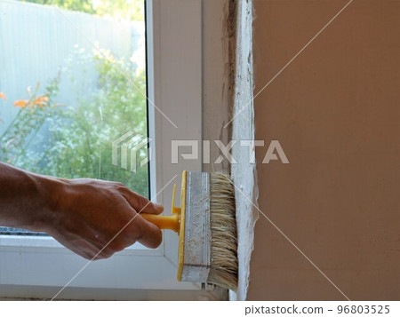 priming the window slope in the room during major repairs and replacement of windows, updating the window opening from the inside by applying a protective layer of primer before painting priming the window slope in the room during major repairs and replacement of windows, updating the window opening from the inside by applying a protective layer of primer before painting 96803525
