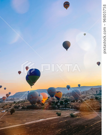 Hot air balloon flying over rocky landscapes in Cappadocia with beautiful sky on background 96803758