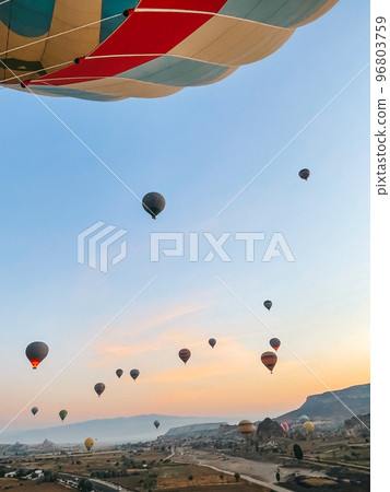 Hot air balloon flying over rocky landscapes in Cappadocia with beautiful sky on background 96803759
