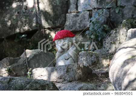 一塊大石頭上戴著紅色羊毛帽的 Jizo 雕像的風景 96804501