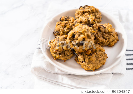 Freshly baked soft oatmeal raisin walnut cookies. 96804847