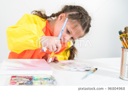 Little girl working on an art project with acrylic paint at homeschool. 96804968
