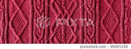 Knitted magenta background. Large knitted fabric with a pattern. Close-up of a knitted blanket. Demonstrating the colors of 2023 - Viva Magenta. Knitted magenta background. Large knitted fabric with a pattern. Close-up of a knitted blanket. Demonstrating the colors of 2023 - Viva Magenta. 96805288