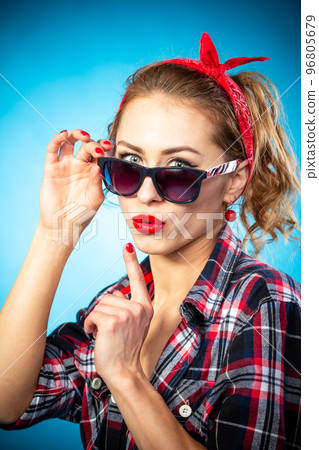 Smiling lovely asian woman dressed in pin-up style dress over blue. Smiling lovely asian woman dressed in pin-up style dress over blue. 96805679