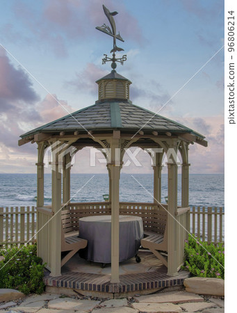 Vertical Puffy clouds at sunset Gazebo with built in seat and table in a beautiful garden at La Vertical Puffy clouds at sunset Gazebo with built in seat and table in a beautiful garden at La 96806214