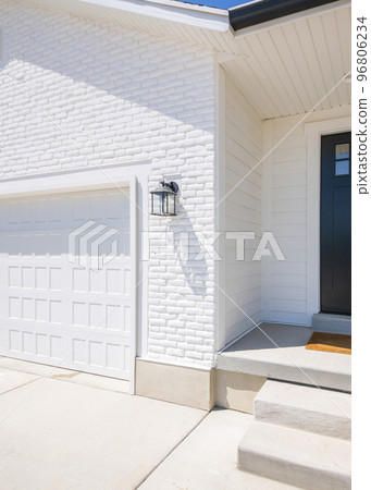 Vertical Facade of a house with white exterior and black front door with glass, doorbell camera and lockbox Vertical Facade of a house with white exterior and black front door with glass, doorbell camera and lockbox 96806234